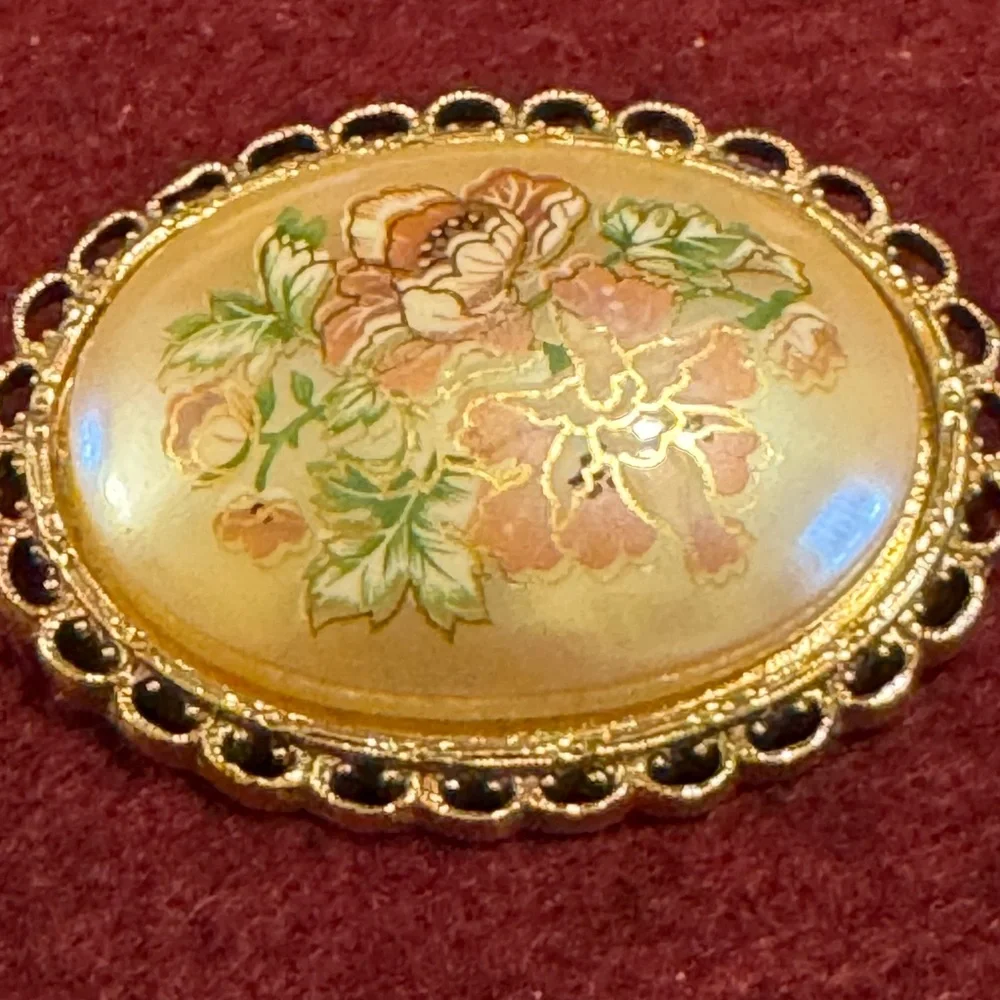Vintage hand painted floral celluloid set in gold tone filigree frame brooch
